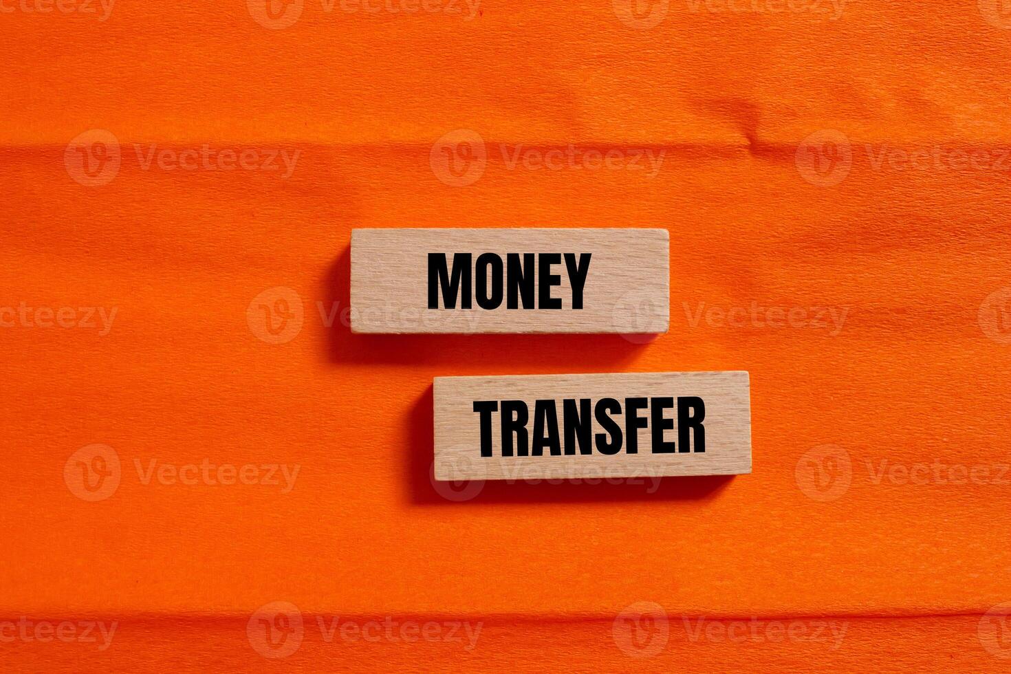 Money transfer message written on wooden blocks with orange background. Conceptual money transfer symbol. Copy space. photo