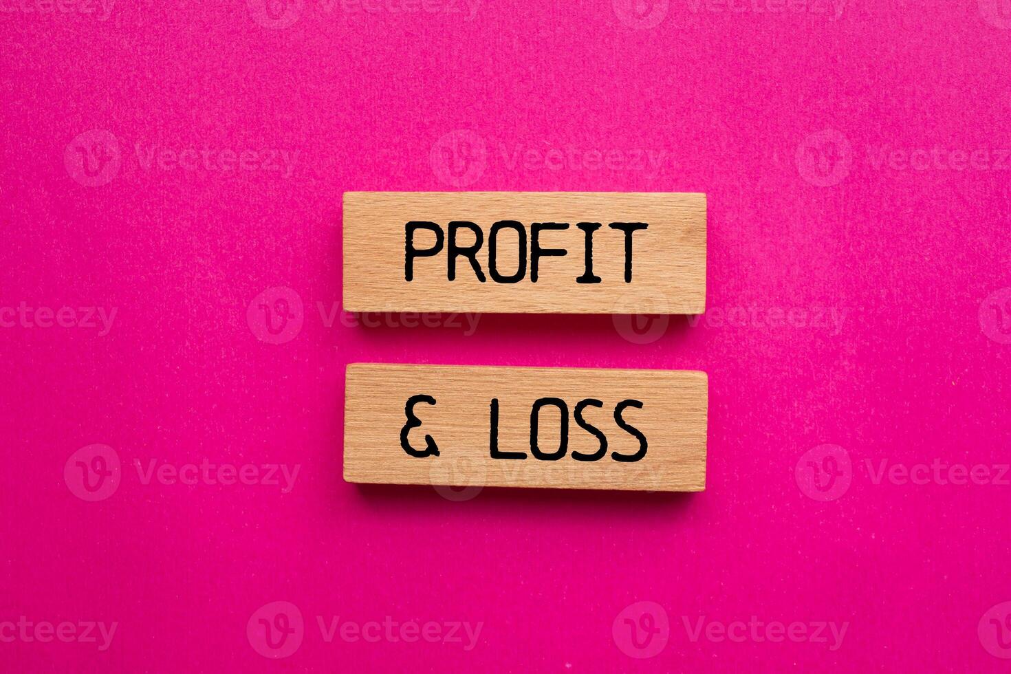Profit and loss message written on wooden blocks with pink background. Conceptual profit and loss symbol. Copy space. photo