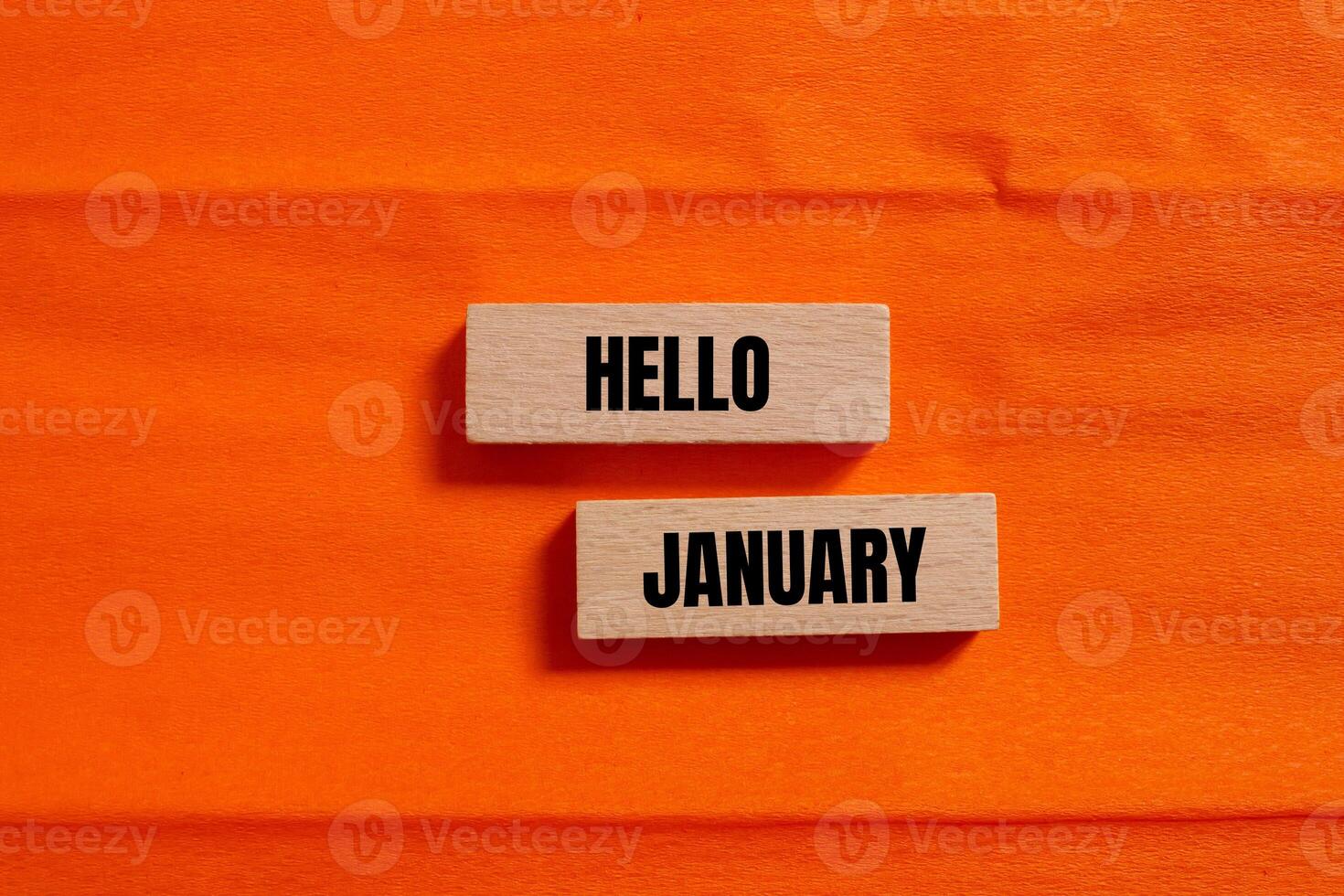 Hello january message written on wooden blocks with orange background. Conceptual hello january symbol. Copy space. photo