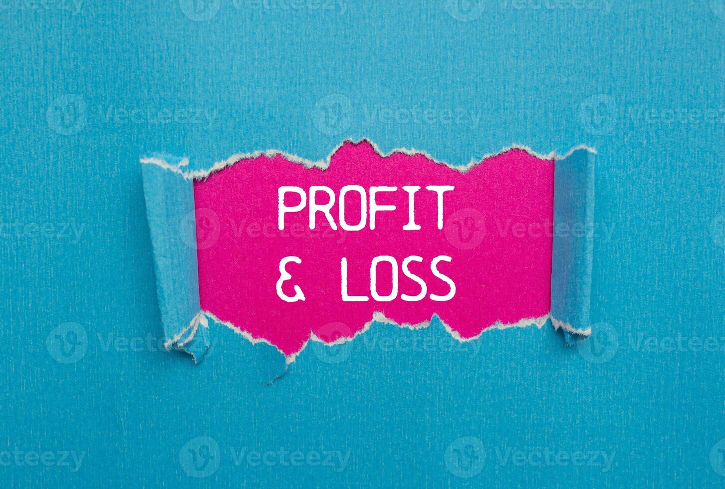 Profit and loss message written on ripped torn blue paper with pink background. Conceptual profit and loss symbol. Copy space. photo