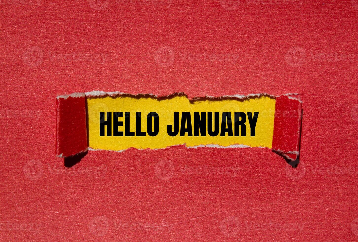 Hello january message written on ripped torn red paper with yellow background. Conceptual hello january symbol. Copy space. photo