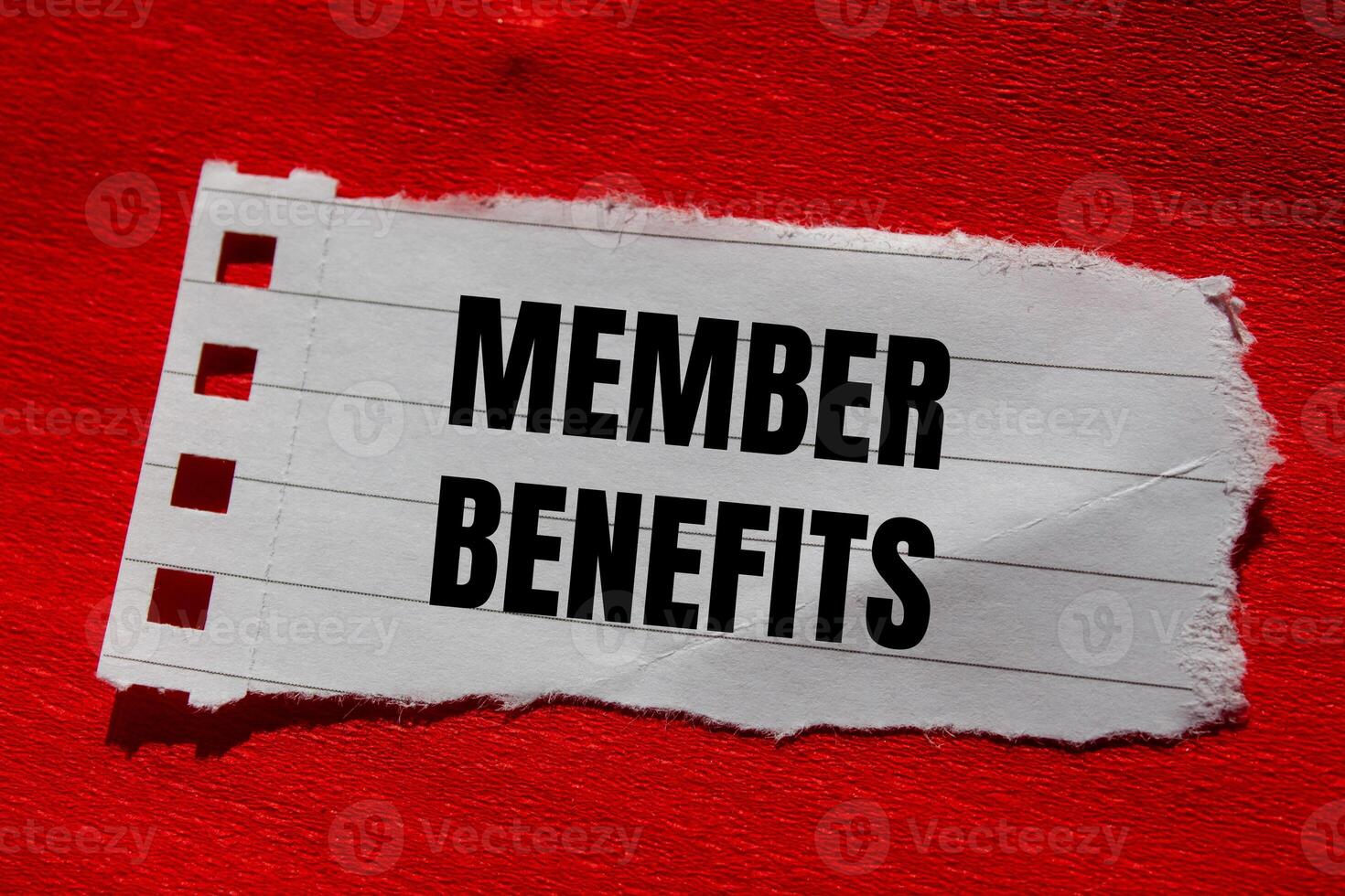 Member benefits message written on ripped torn paper piece with red background. Conceptual member benefits symbol. Copy space. photo