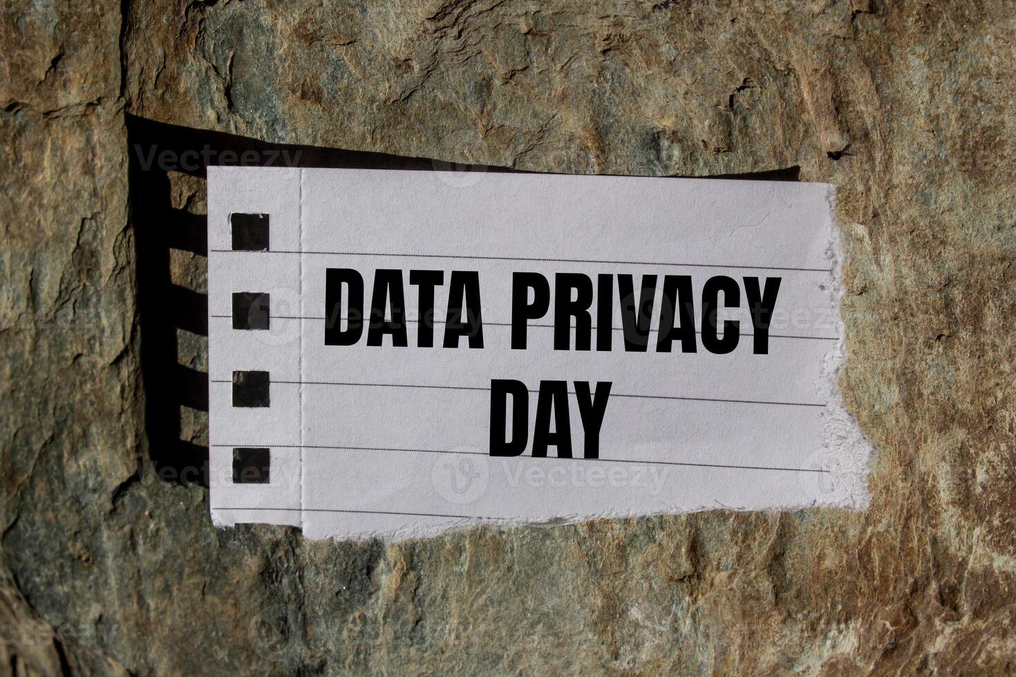 Data privacy day message written on ripped torn paper piece with stone background. Conceptual data privacy day symbol. Copy space. photo