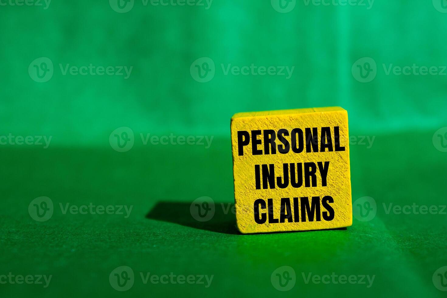 Personal injury claims message written on yellow wooden cube with green background. Conceptual personal injury claims symbol. Copy space. photo