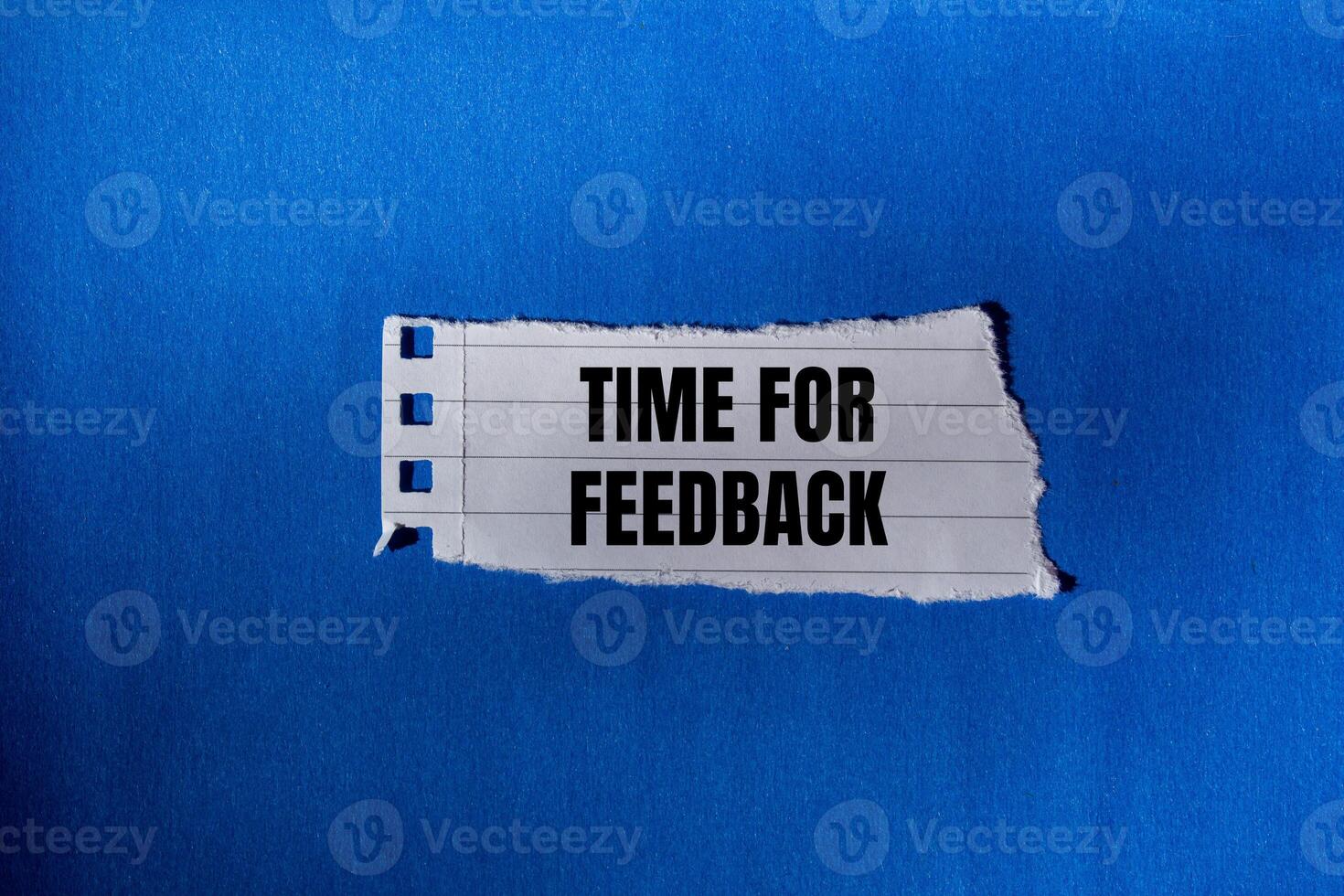 Time for feedback message written on ripped torn paper piece with blue background. Conceptual time for feedback symbol. Copy space. photo