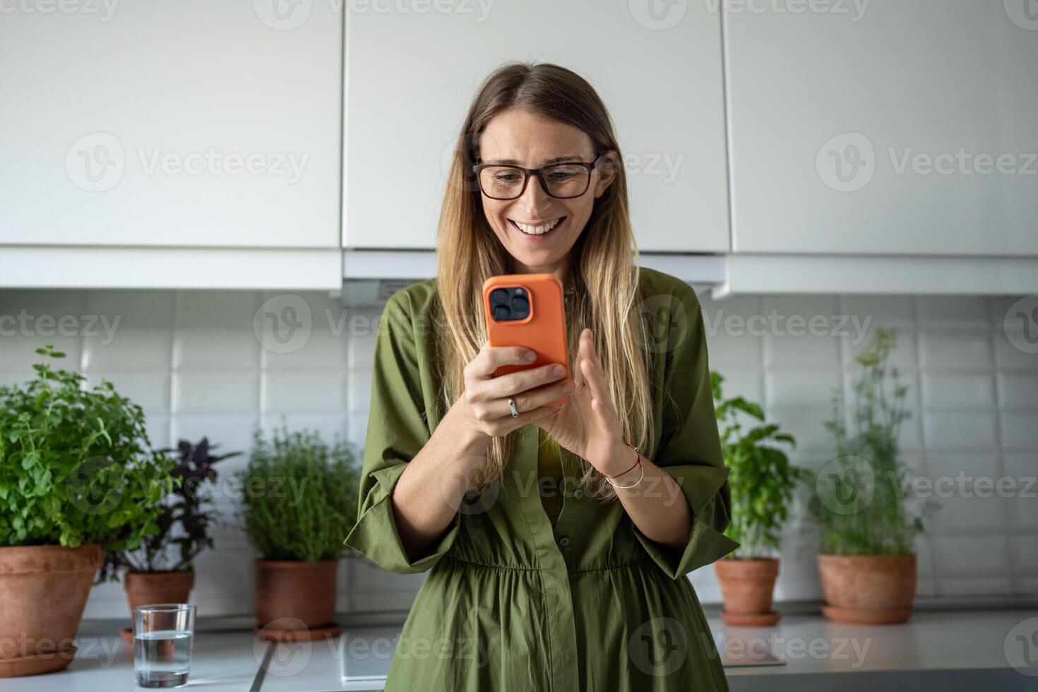 Happy millennial Scandinavian woman reading message in cellphone smiling enjoy communication at home photo