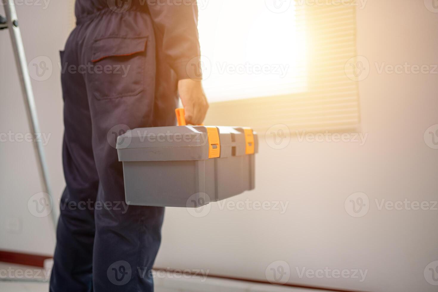 Worker Holding Toolbox with Sunlight in Modern Interior photo