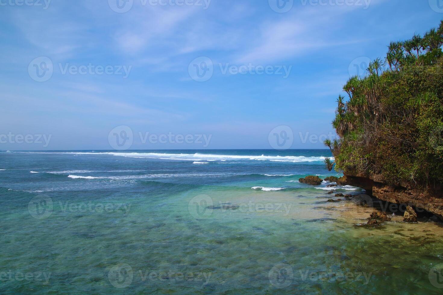 Bale Kambang Beach in East Java with a beautiful beach view on a sunny day with a blue sky horizon and sea foam waves photo