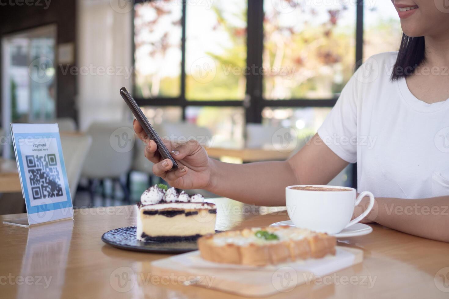 Woman use smartphone to scan QR code for order menu in cafe restaurant with a digital delivery. Choose menu and order accumulate discount. E wallet, technology, pay online, credit card, bank app. photo