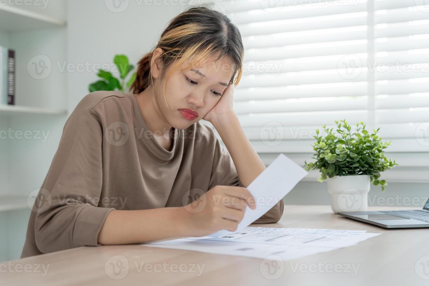 Stressed and headache asian woman with large bills or invoices no money to pay to expenses and credit card debt. shortage, Financial problems, mortgage, loan, bankruptcy, bankrupt, poor, empty wallet photo