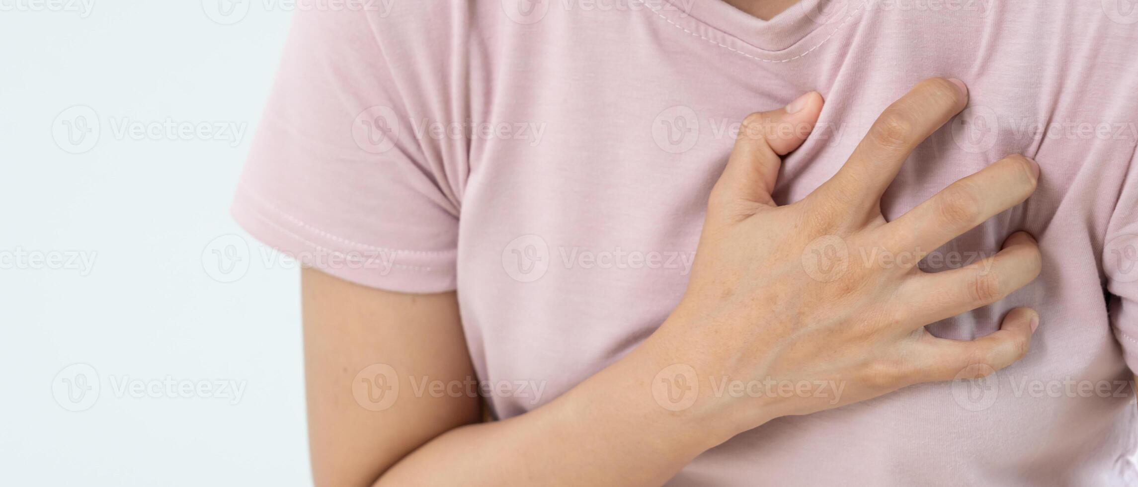 hand hold chest with heart attack symptoms, asian woman have chest pain caused by heart disease, leak, dilatation, enlarged coronary heart, press on the chest with a painful expression photo