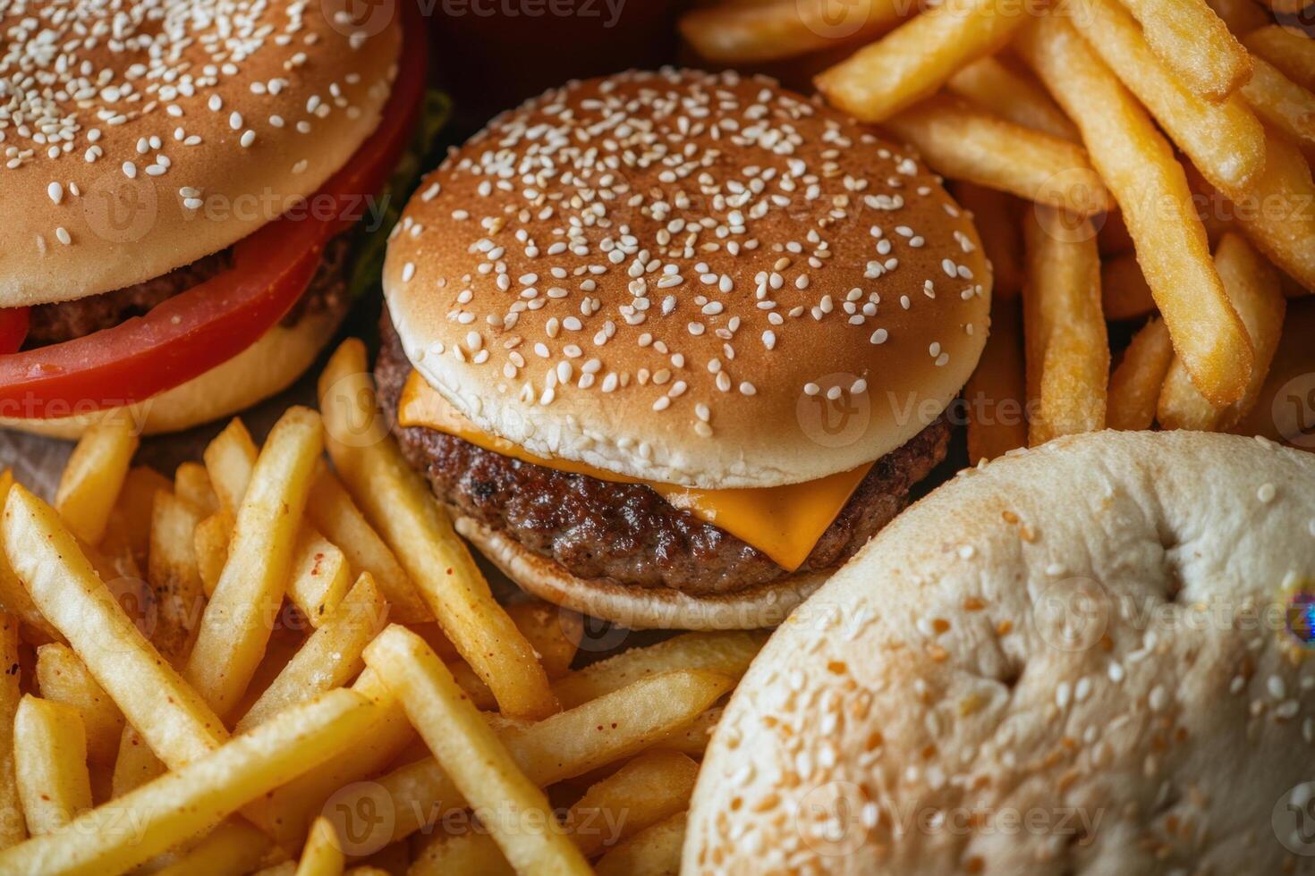 A hamburger, french fries and a bun are shown photo