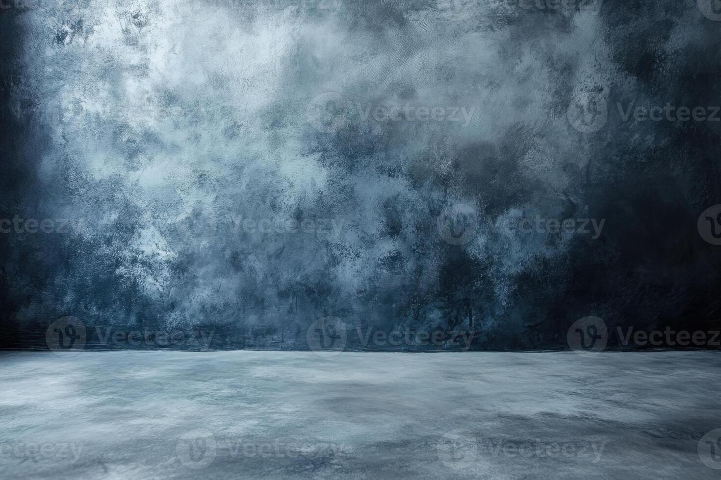 A dark blue concrete wall with a spotlight shining on the floor. photo