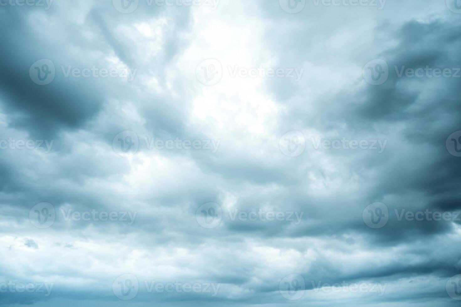 A low angle view of a cloudy sky with light shining through the clouds. photo