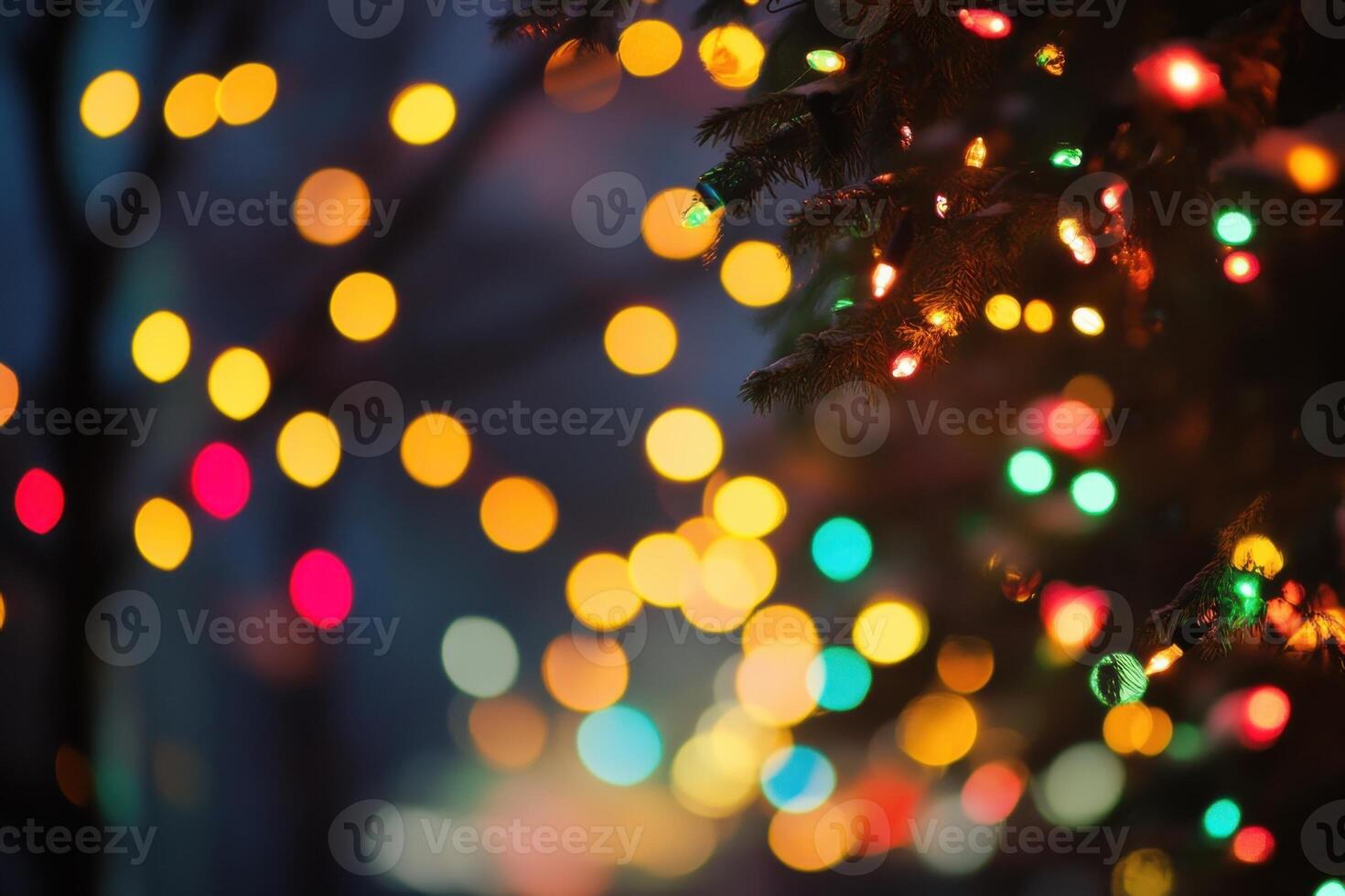 A close-up of colorful Christmas lights strung on a pine branch with an out-of-focus background of more lights. photo