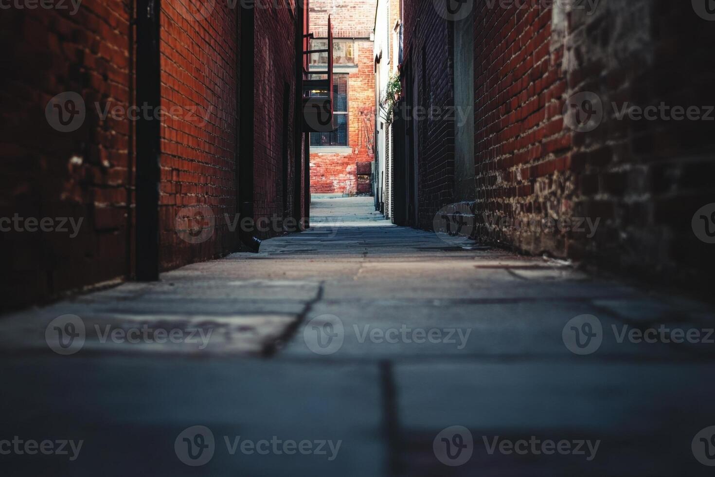A narrow brick alleyway with a paved path leading to an unknown destination. photo