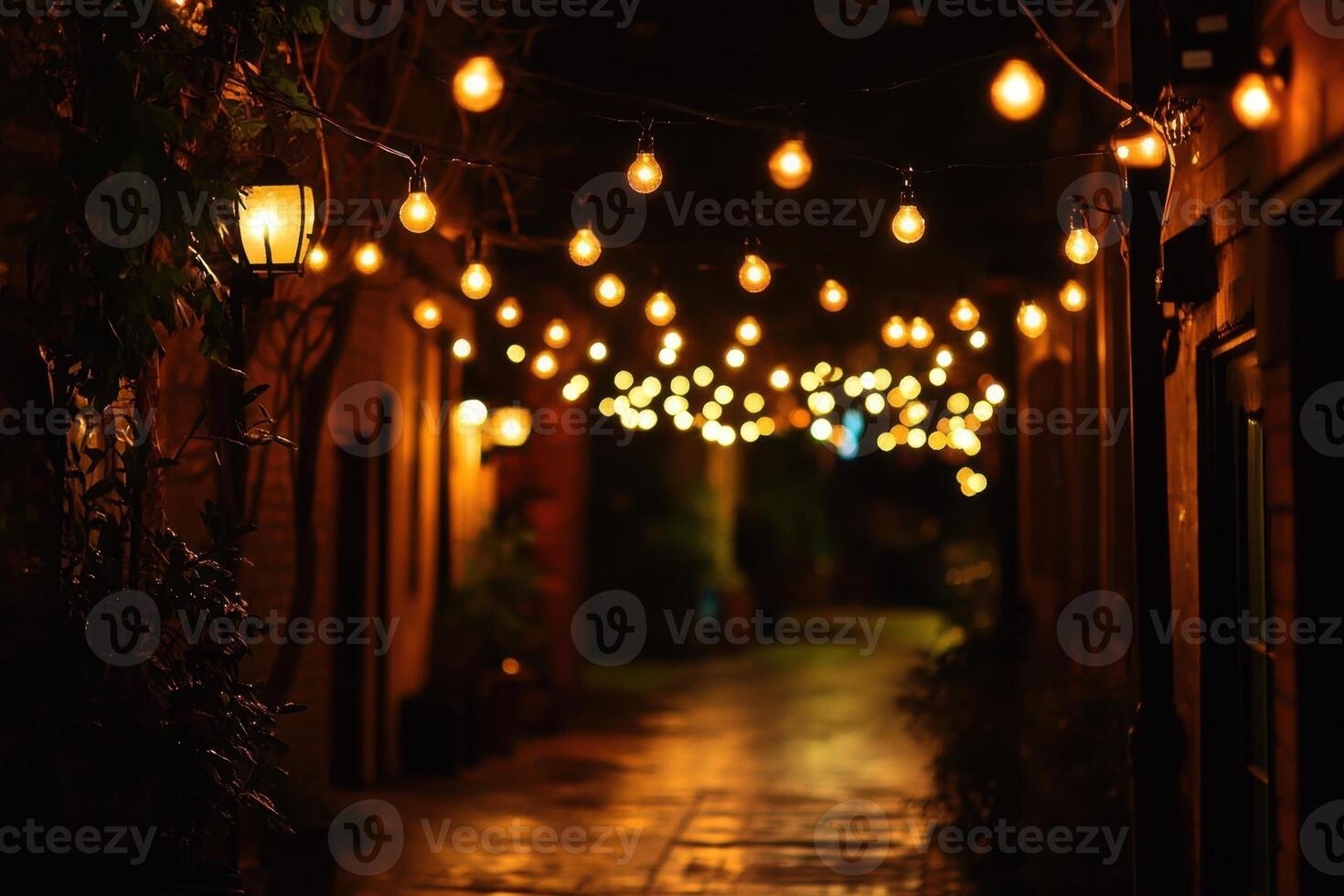 A narrow, brick-lined alleyway at night, illuminated by string lights. photo