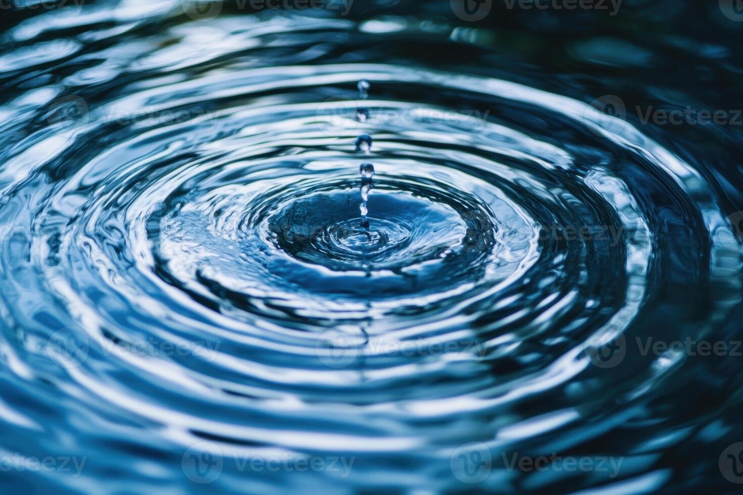 A single drop of water creates ripples on the surface of a still pond. photo