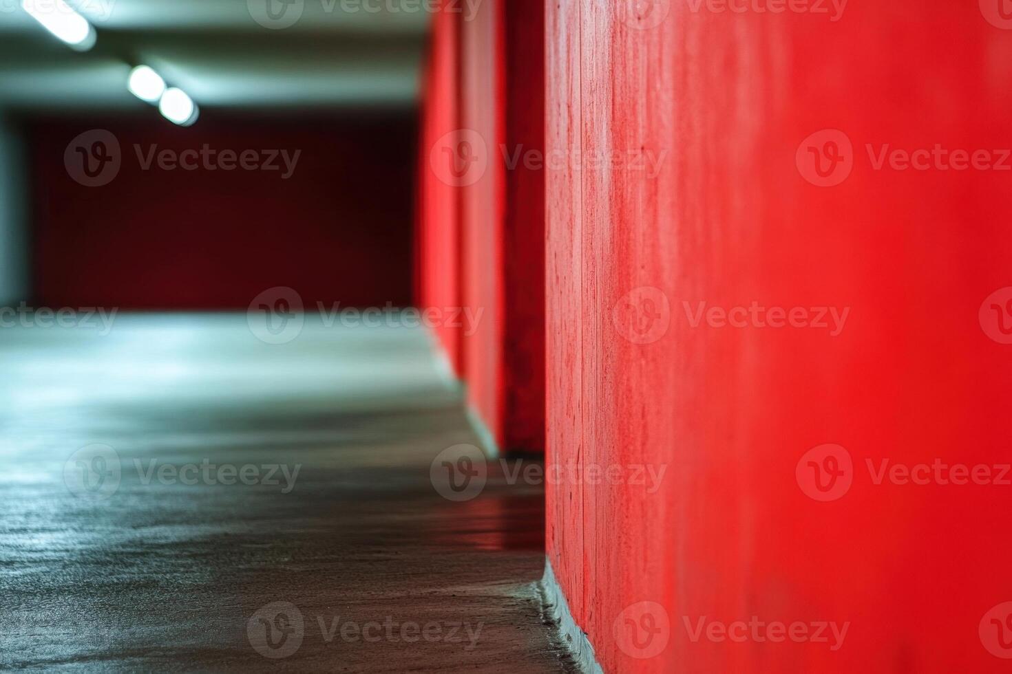 Red wall and concrete floor in an underground parking garage. photo