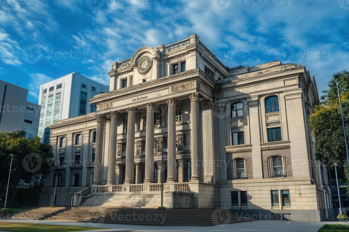 A grand, historic courthouse with ornate columns and a clock tower, against a clear blue sky. photo