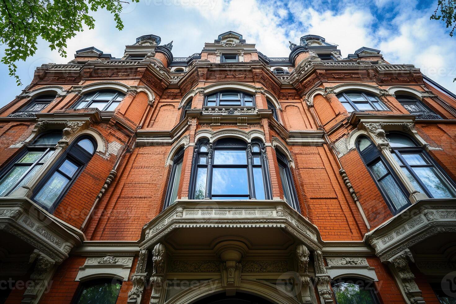 Red brick Victorian mansion with intricate architectural details. photo