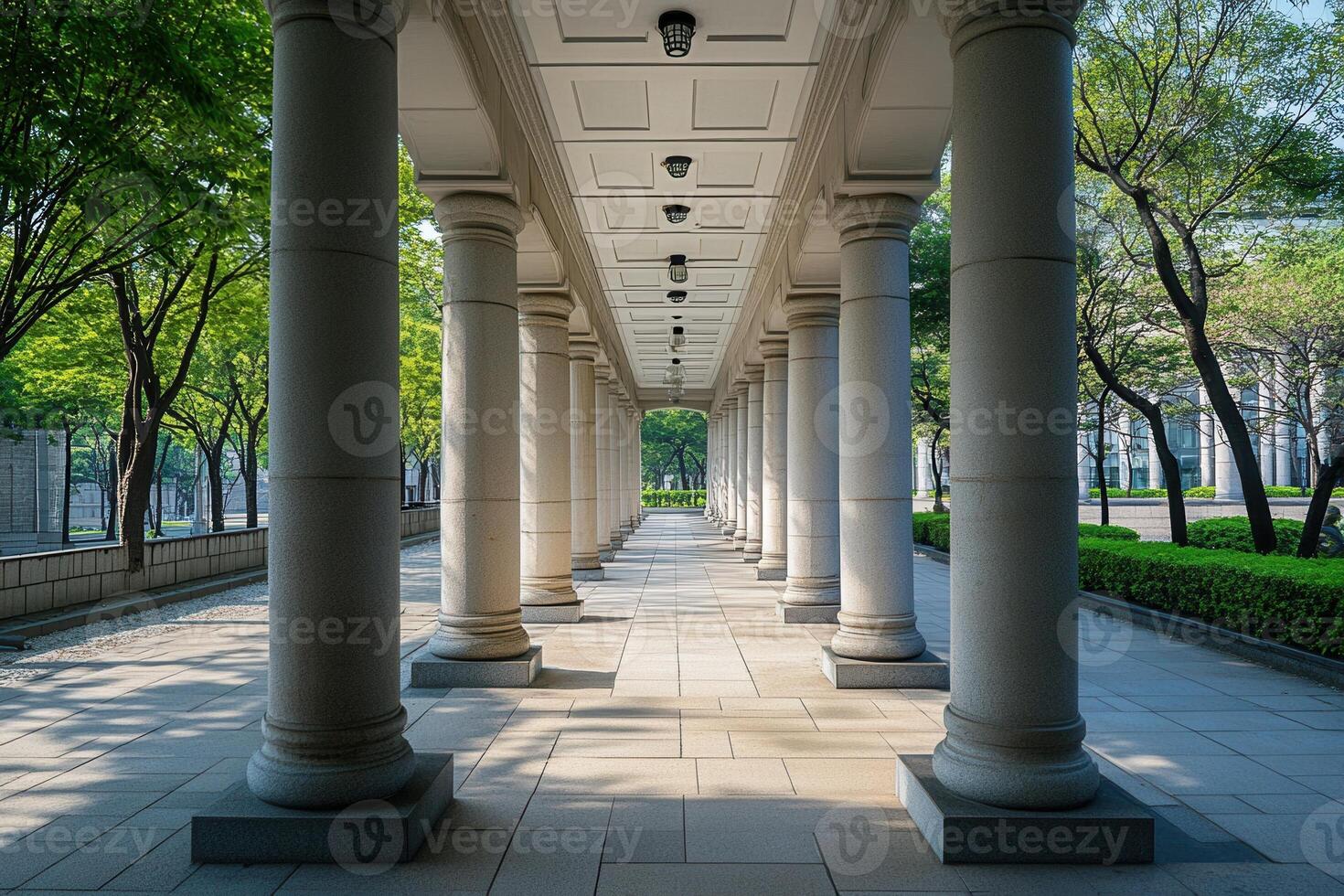 A long walkway lined with white columns, leading towards the light. photo