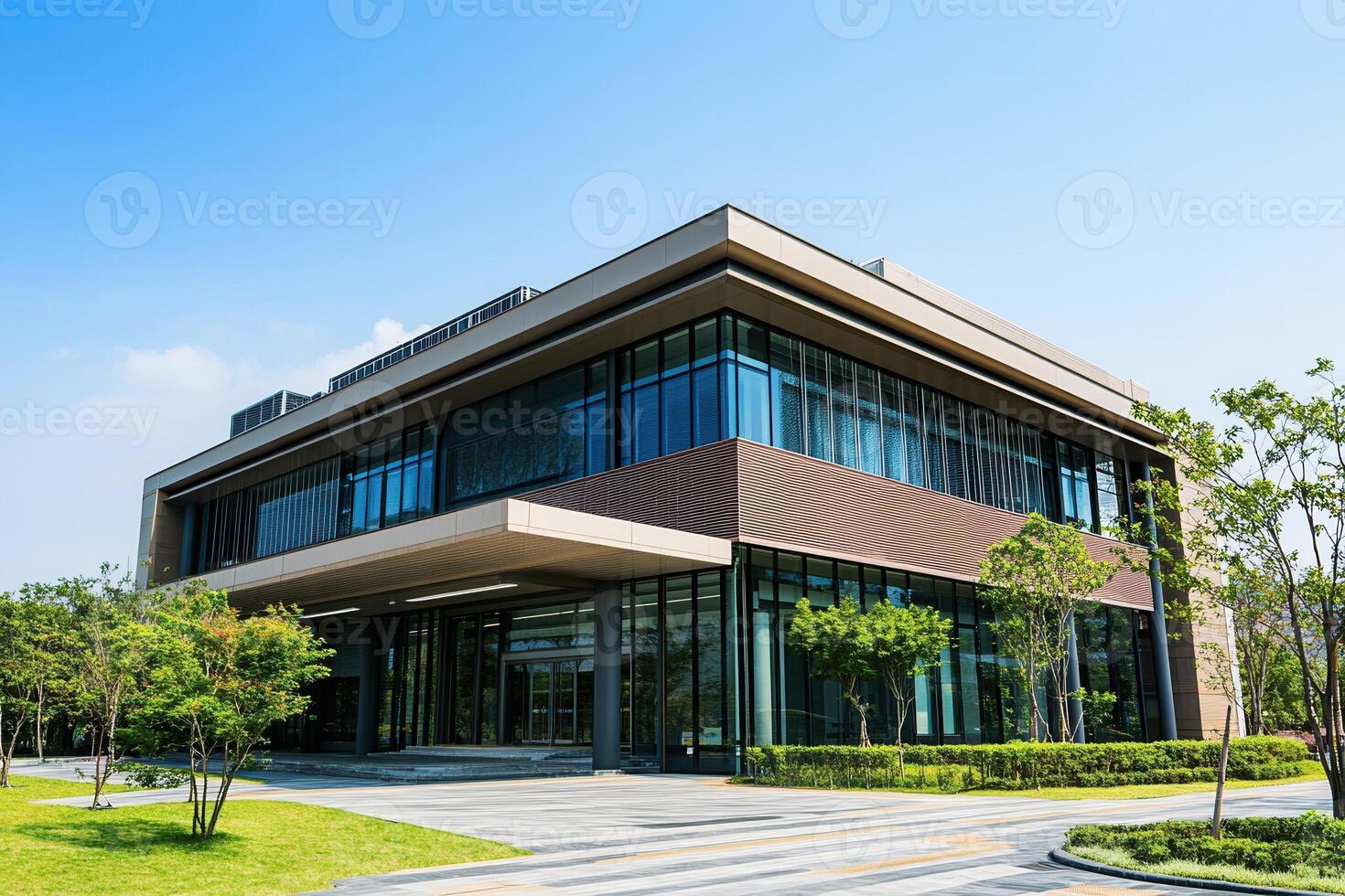 Modern office building with glass facade and green landscaping. photo