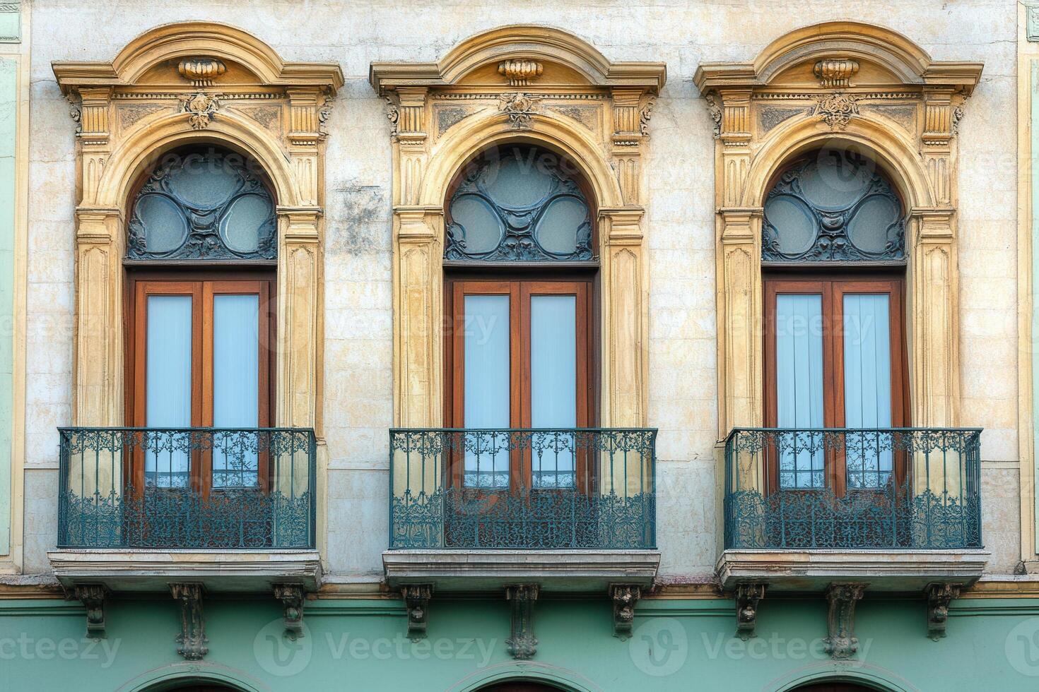 Three arched windows with balconies on a building facade. photo