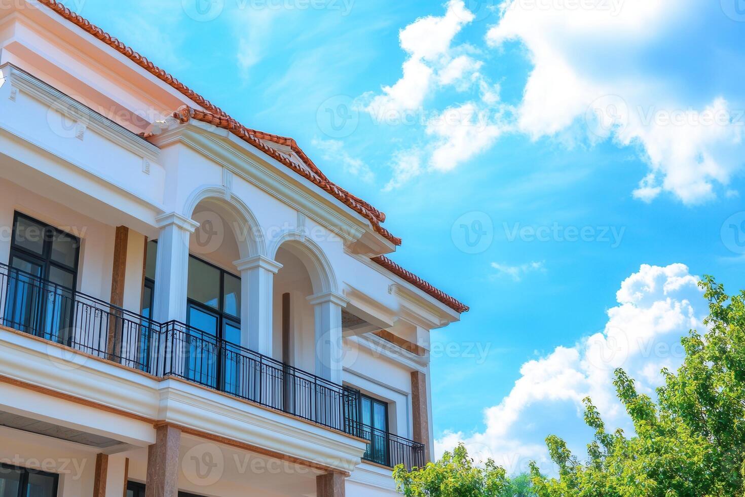 White house with balcony against blue sky. photo