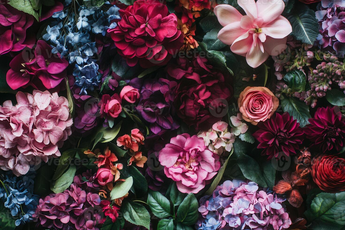 A vibrant floral wall made up of various flowers, such as hydrangeas, roses, and peonies, in shades of pink, red, purple, and blue. photo