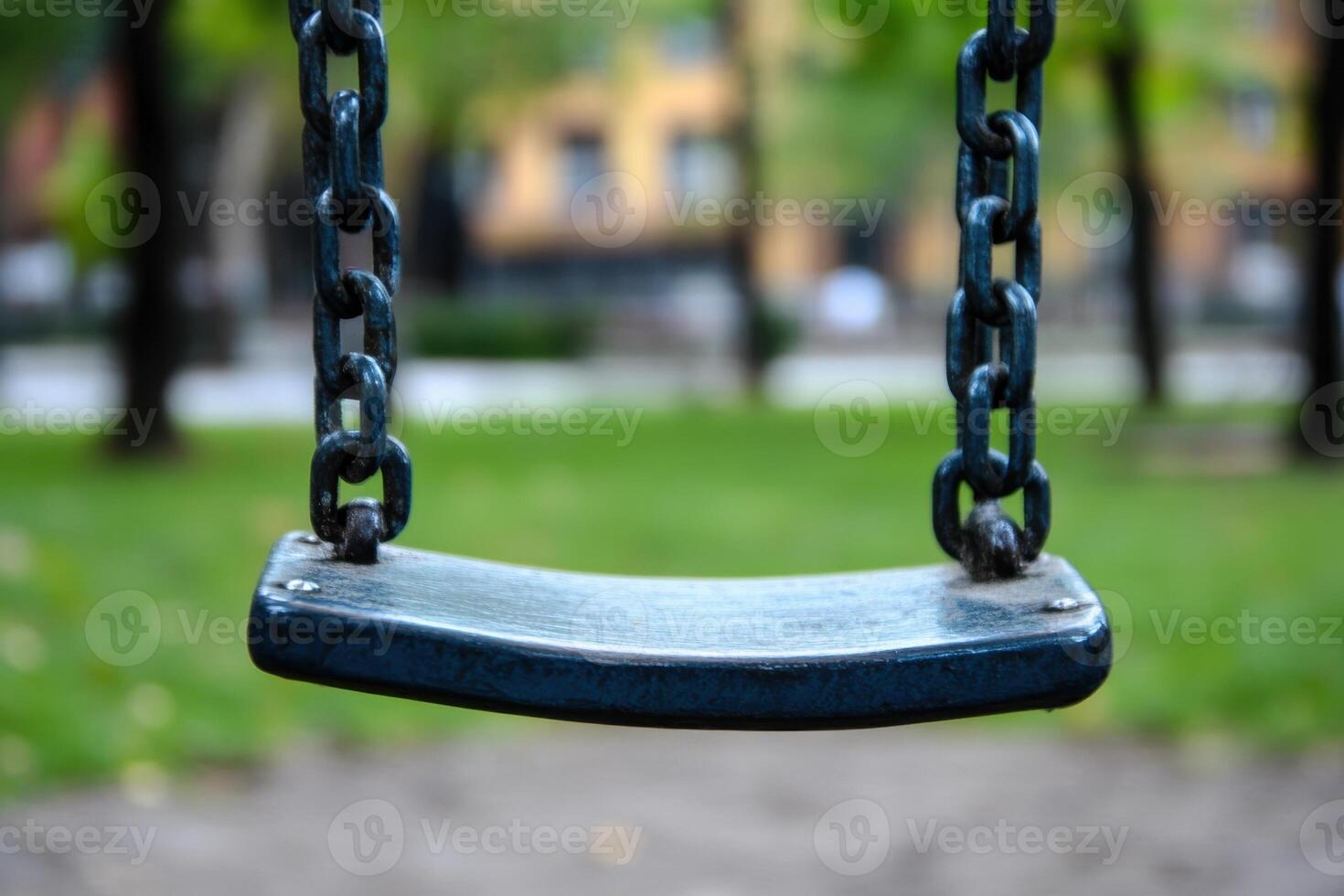 A close-up of an empty swing set in a park. photo