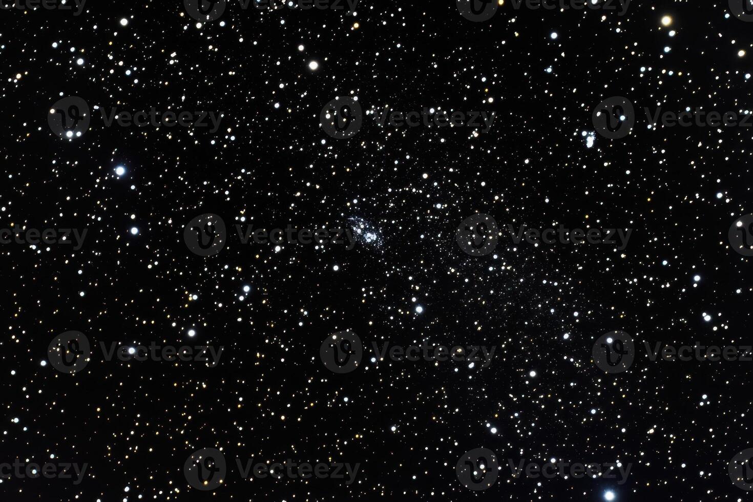 A faint, fuzzy galaxy visible amongst a field of stars. photo