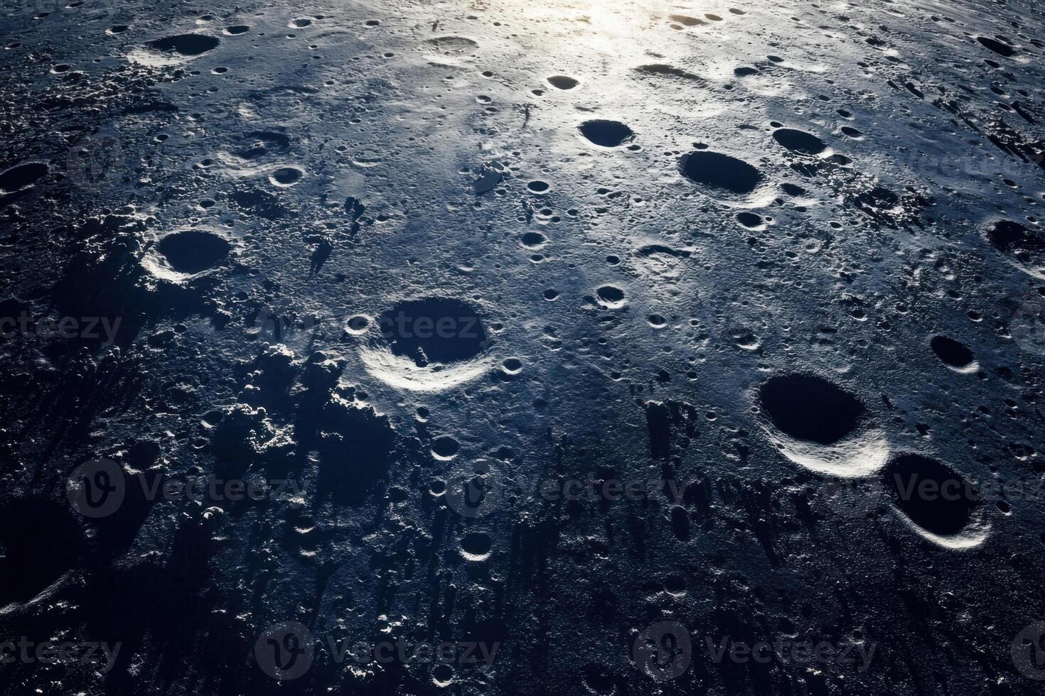 Cratered surface of the moon illuminated by the sun. photo