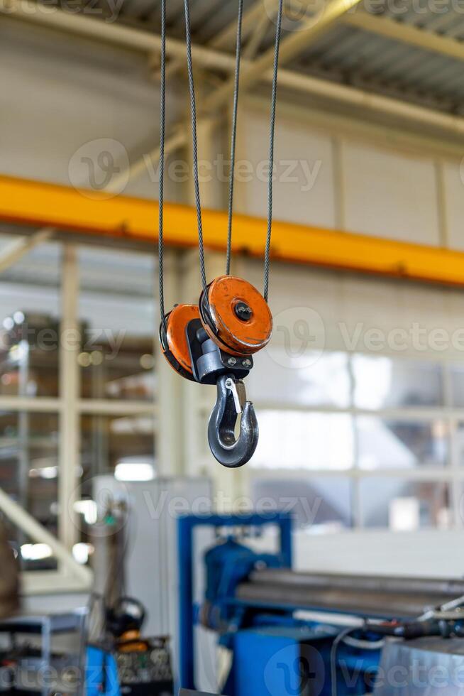 Metal factory construction hook for transportation. Crane hook inside factory building. photo