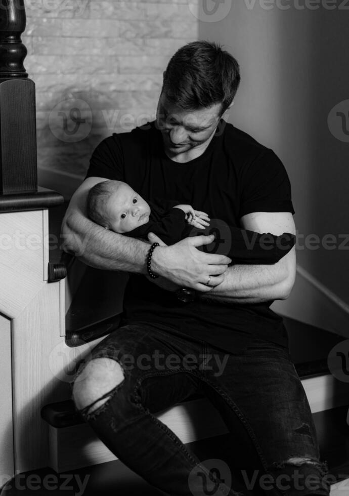 Loving father with newborn boy. Cute man holding small baby. photo