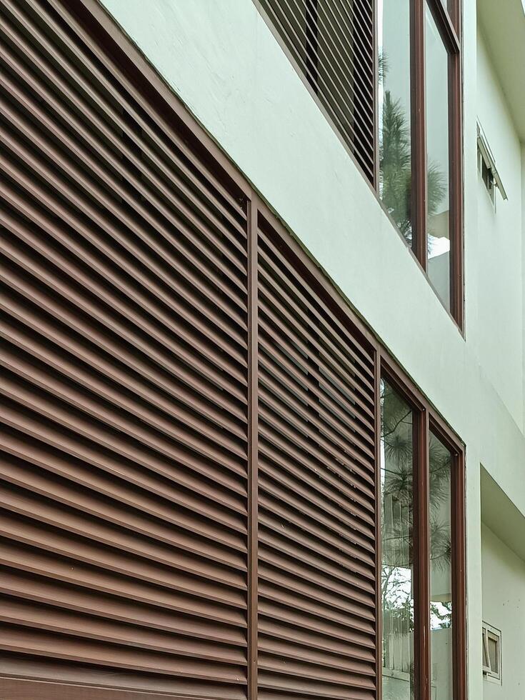 Modern Building Facade with Brown Louvers and Large Glass Windows photo