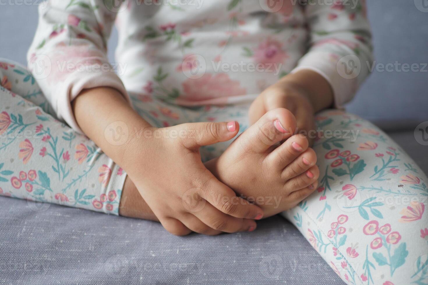 child girl suffering pain on feet photo