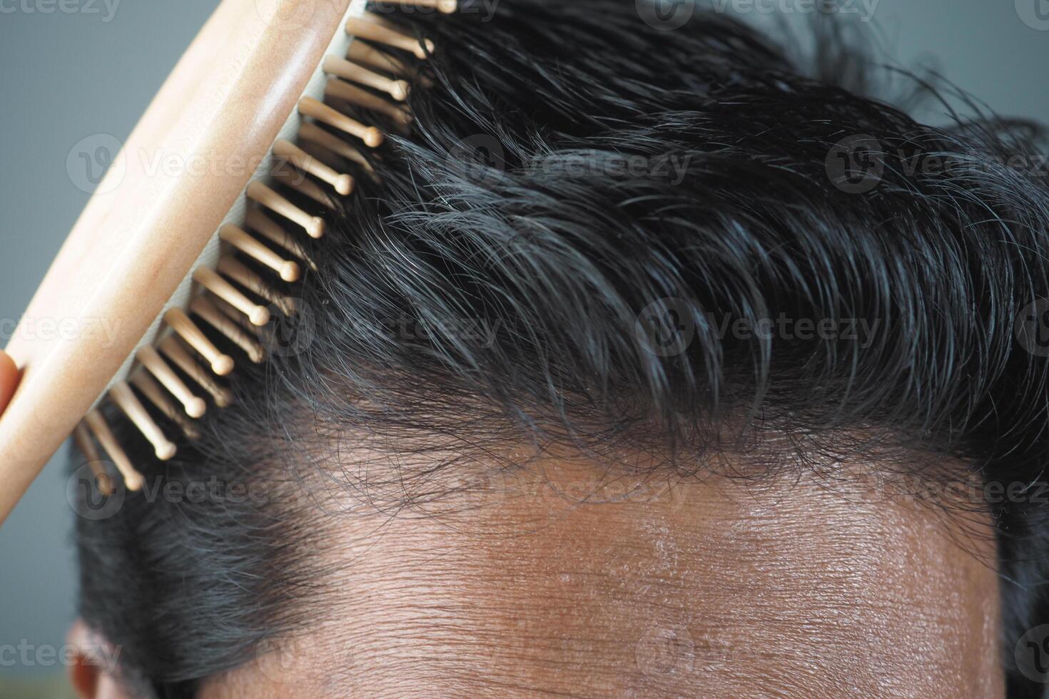 Grooming Essentials A CloseUp of Hair Combing with a Beautiful Wooden Brush for Haircare photo