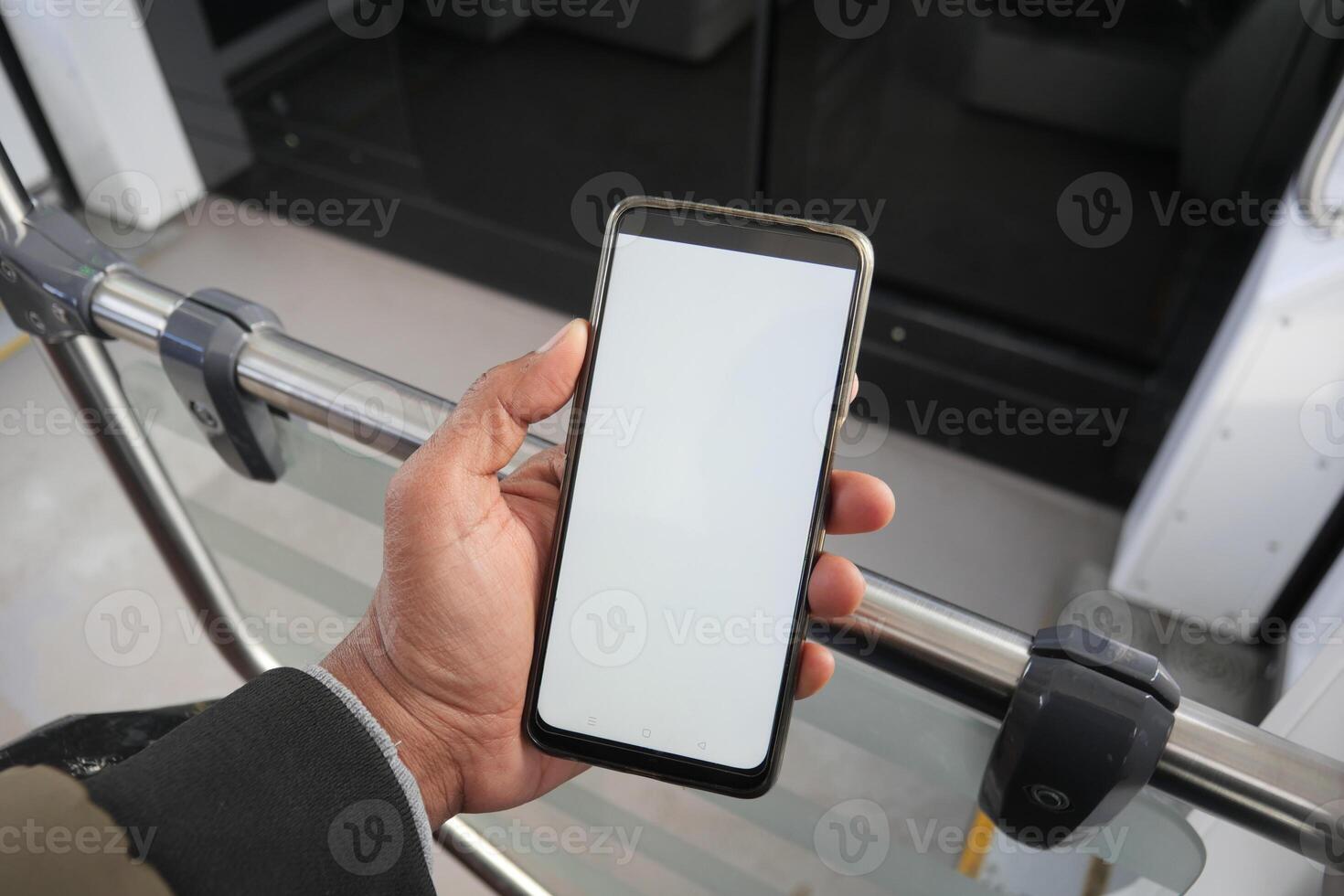 young man hand using smart phone with green screen inside of metro train photo