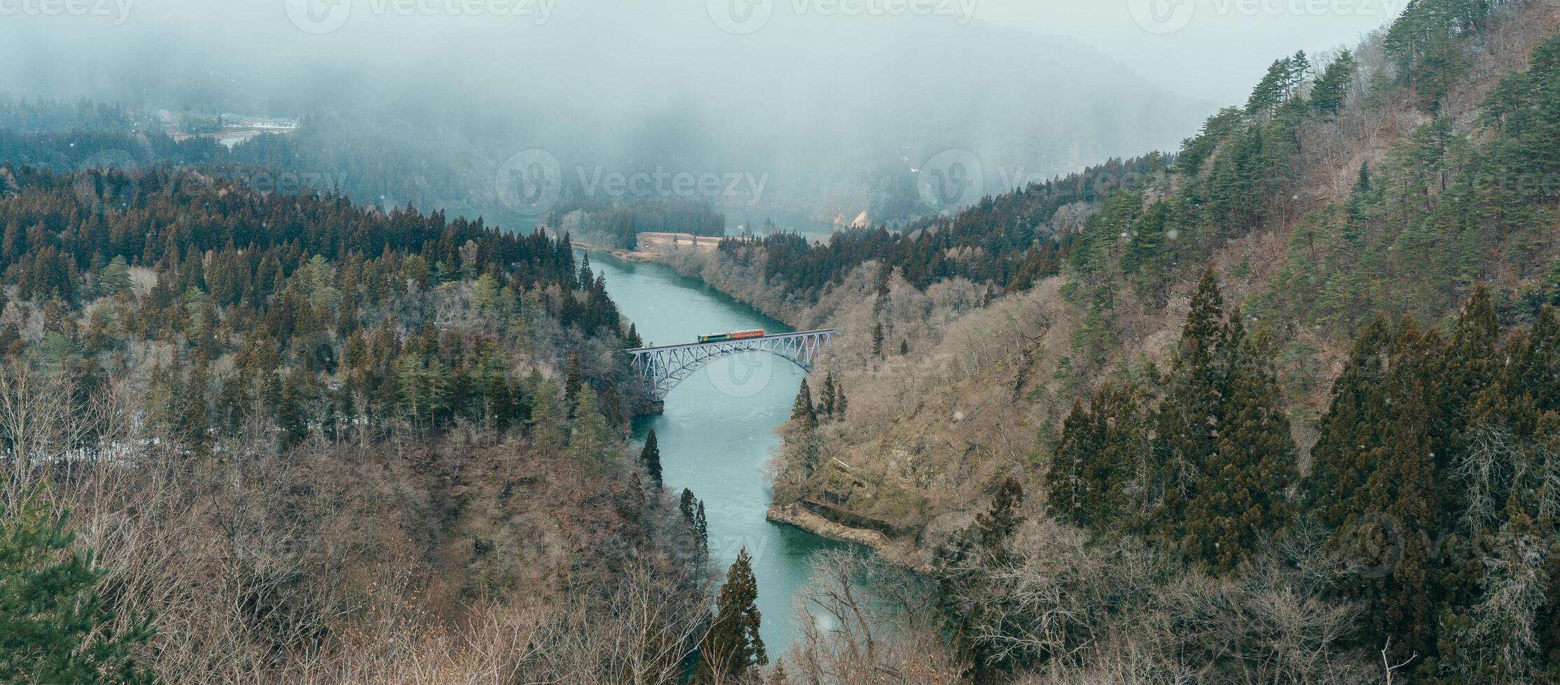 Panoramic View of Japan local train with Tadami river and bridge. Tadami Railway Line in The Valley at Mishima Machi, Aizu, Fukushima Prefecture, Japan. Landmark and iconic spot for tourist attraction photo