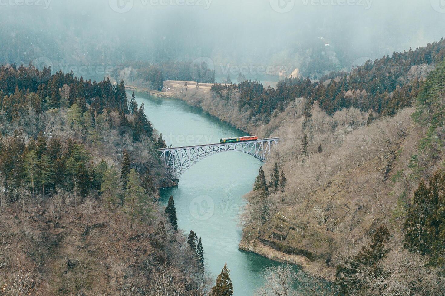 Panoramic View of Japan local train with Tadami river and bridge. Tadami Railway Line in The Valley at Mishima Machi, Aizu, Fukushima Prefecture, Japan. Landmark and iconic spot for tourist attraction photo