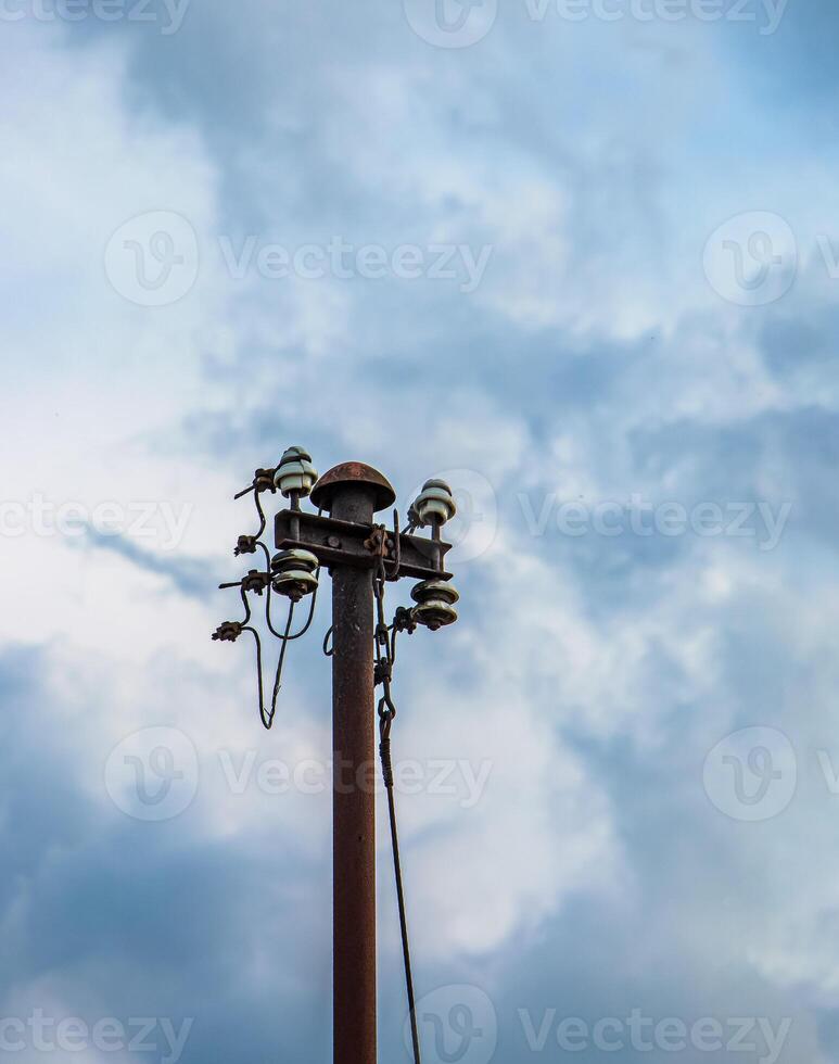 Old street concrete pillar with rusty iron part at top and cut wires. Installation or dismantling of electricity. Broken energy pole. photo