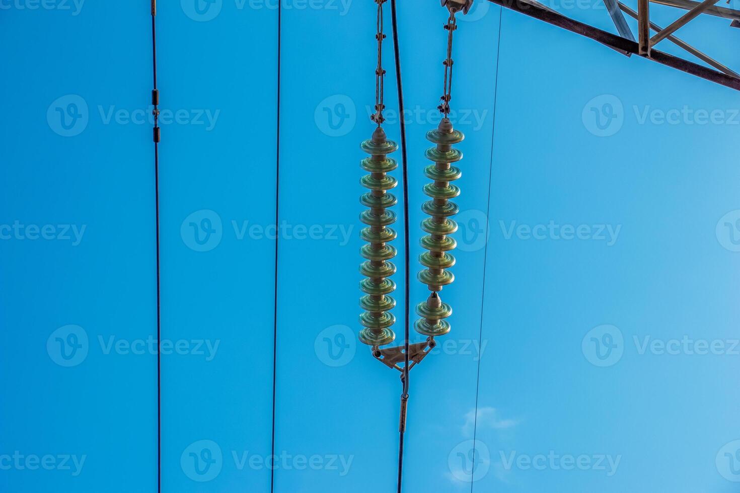 High voltage electric power lines on pylons in blue sky. photo
