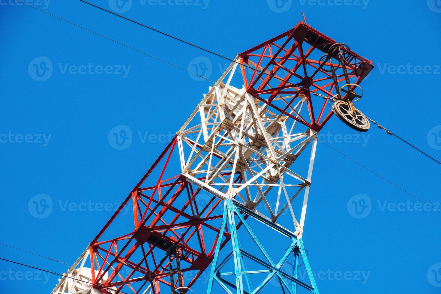 High voltage electric power lines on pylons in blue sky. photo