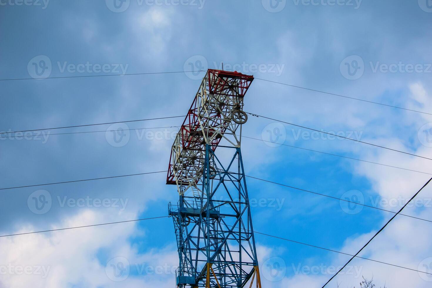 High voltage electric power lines on pylons in blue sky. photo