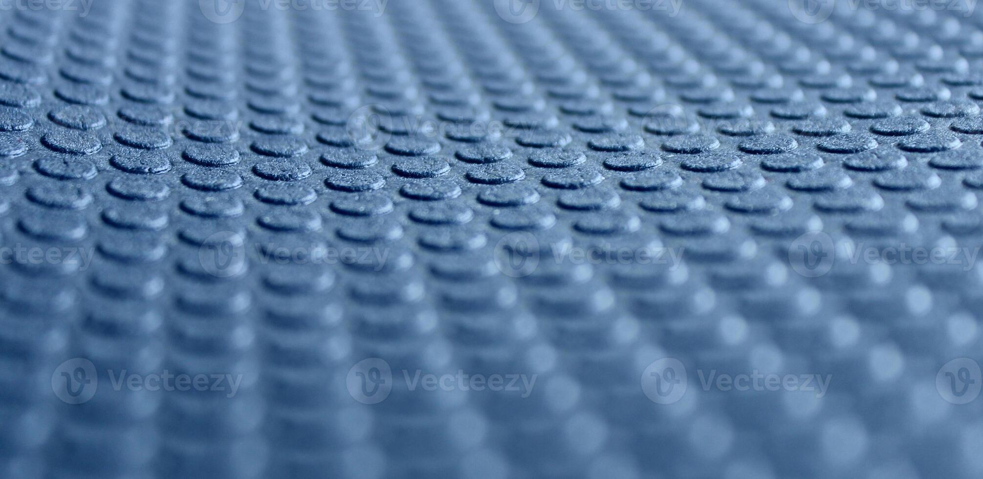 Round embossed pattern on a blue porous material with defocused top and bottom edges. 3d background stock photo