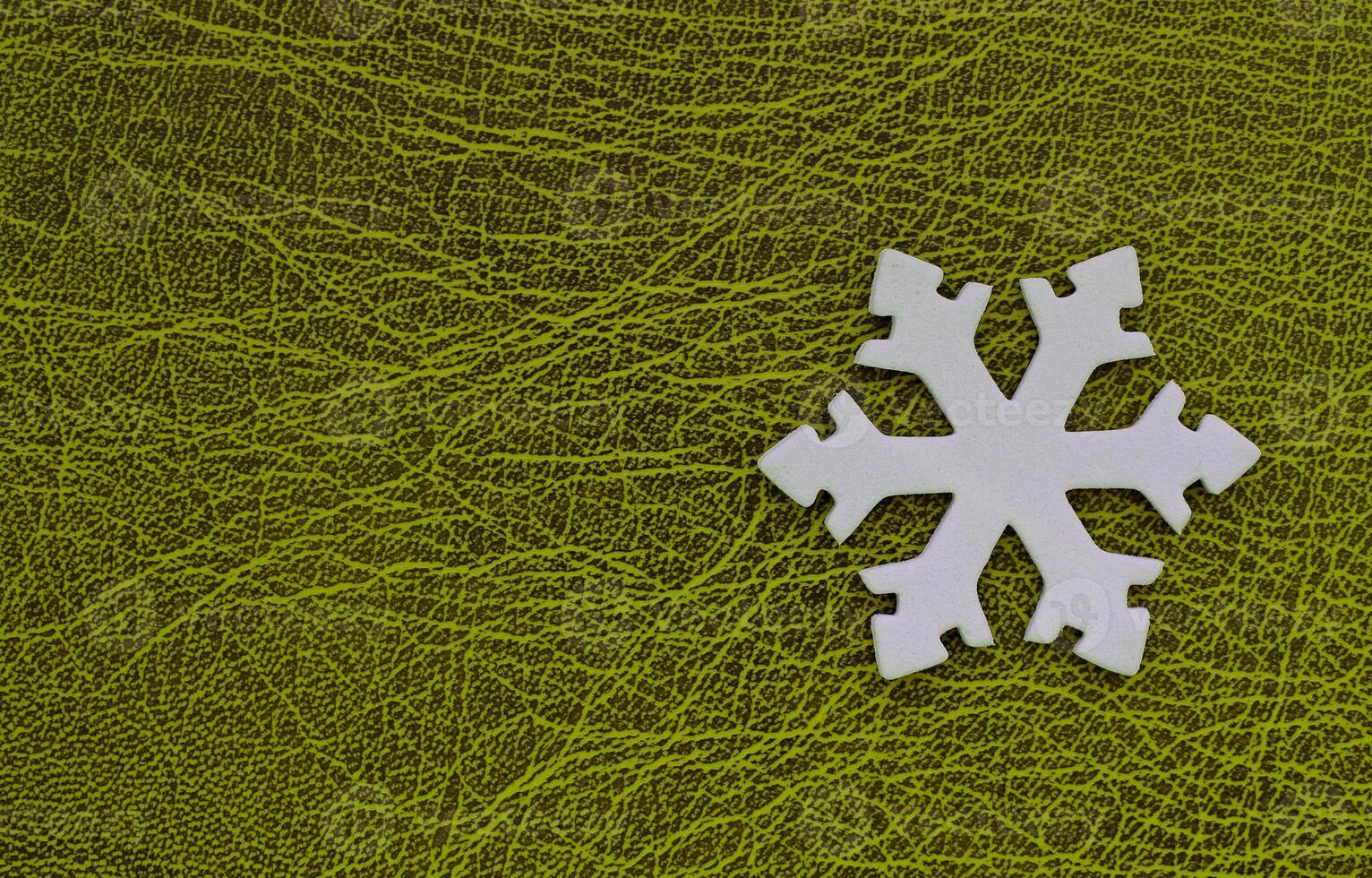 Artificial Snowflake Isolated On Green Patterned Surface With Empty Space At A Side Of Image. Winter Background Design. White 3D Printed Snowflake On Green photo
