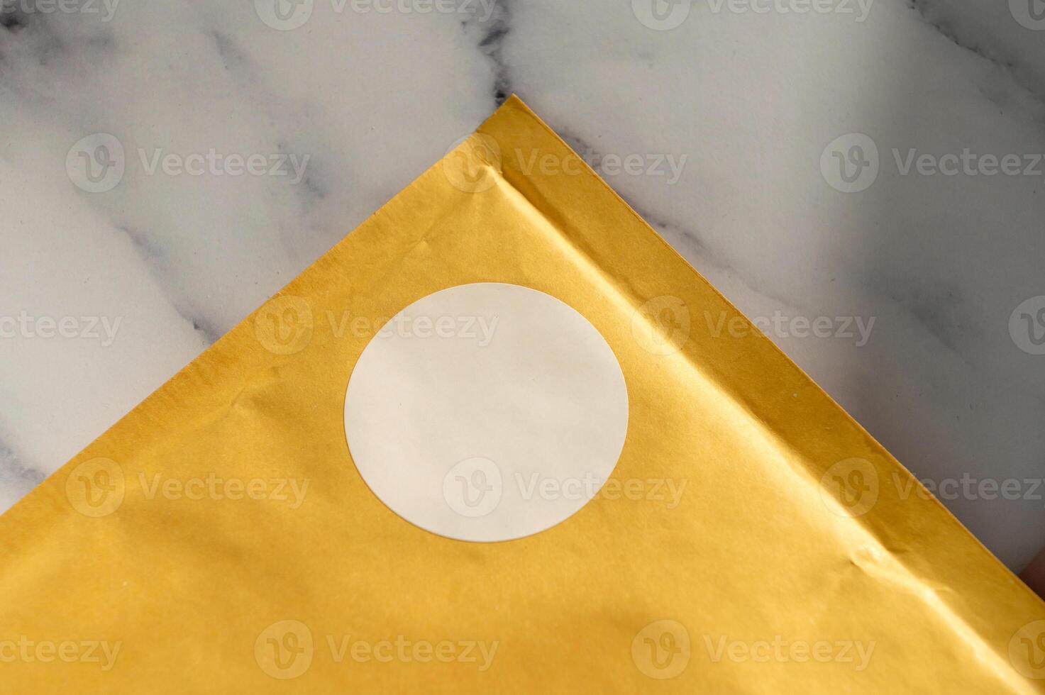 Brown envelope with white circular sticker on a marble background. photo