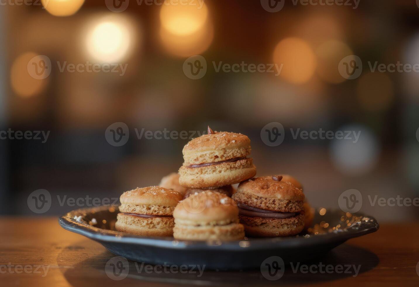 A plate of macarons sitting on top of a wooden table photo