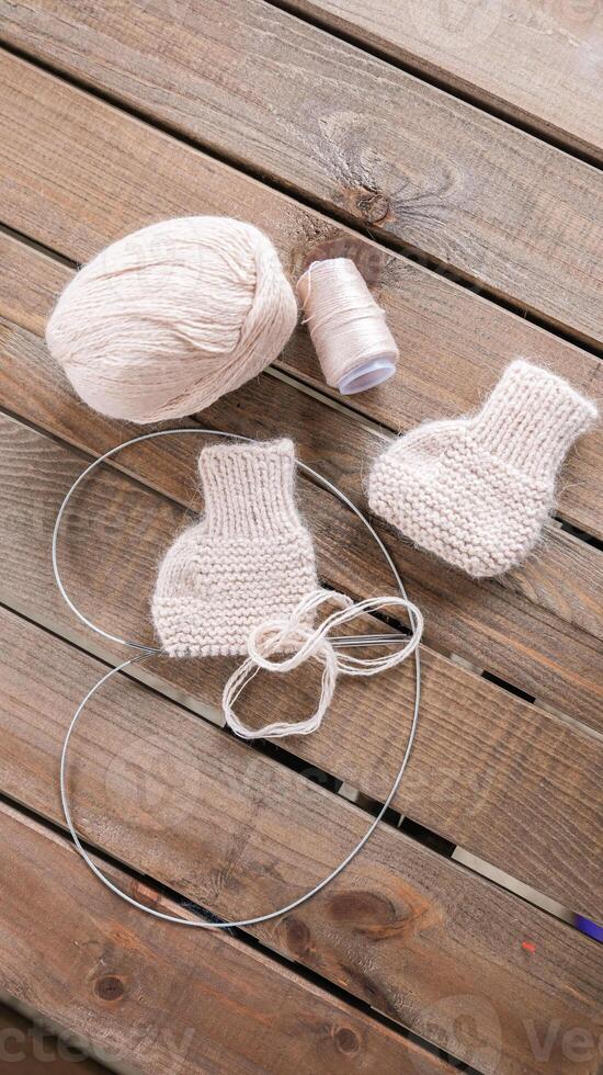 Wool yarn in different colors with wooden double point needles. The needles are being used for knitting socks, mittens or other projects joined in the round. photo